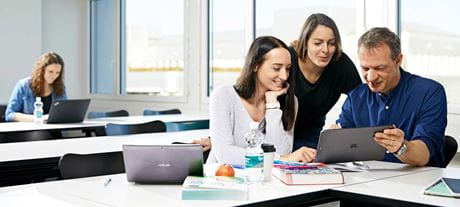 Drei Personen arbeiten an einem Laptop